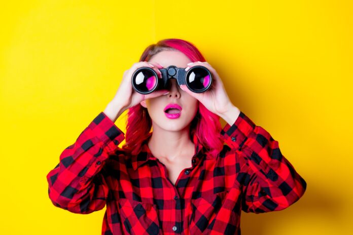Young redhead girl with binoculars